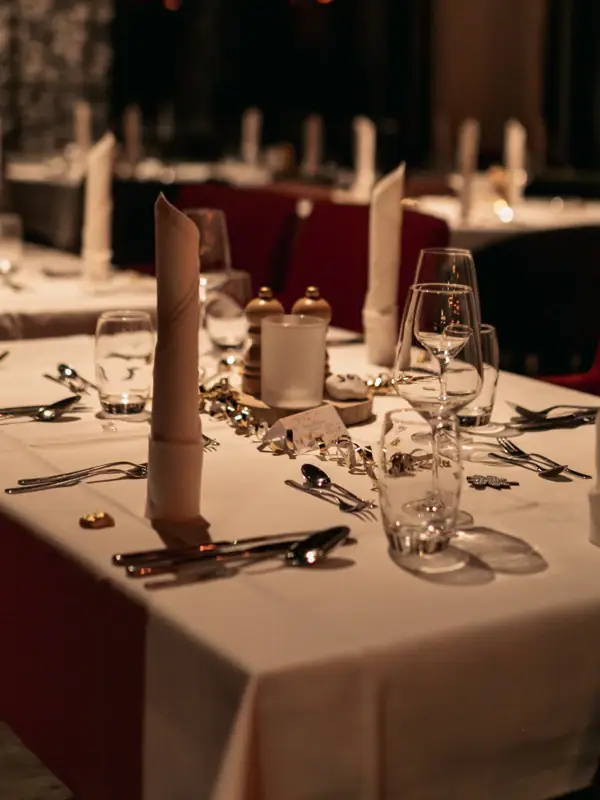 Festlich gedeckter Tisch Ein Tisch, gedeckt für eine Dinnerparty, mit Kerzen und Tischgedeck.