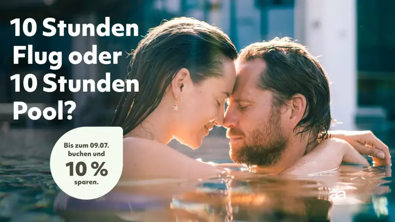 Sommerurlaub Ein Mann und eine Frau küssen sich im Wasser.
