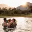 Außenpool aja Ruhpolding Eine Familie genießt gemeinsam einen Moment im Wasser bei Sonnenuntergang, mit Blick auf die malerische Berglandschaft rund um das aja Ruhpolding.