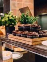 Ein Holztablett mit Schokoladenmuffins steht auf einem Buffet.