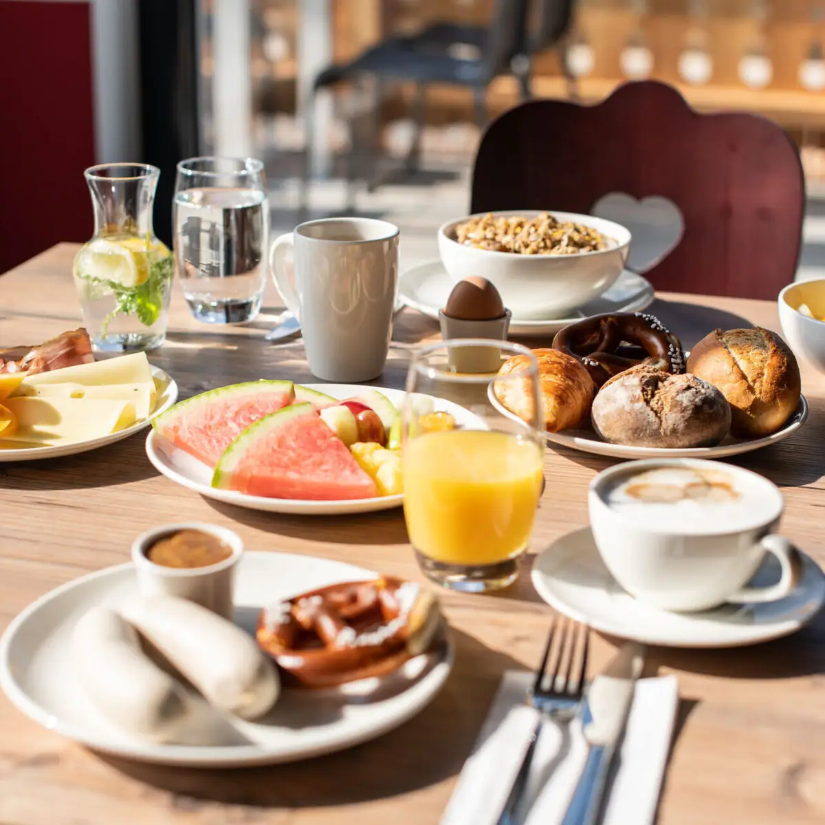 Frühstück im aja Ruhpolding Ein Tisch mit verschiedenen Speisen und Geschirr.