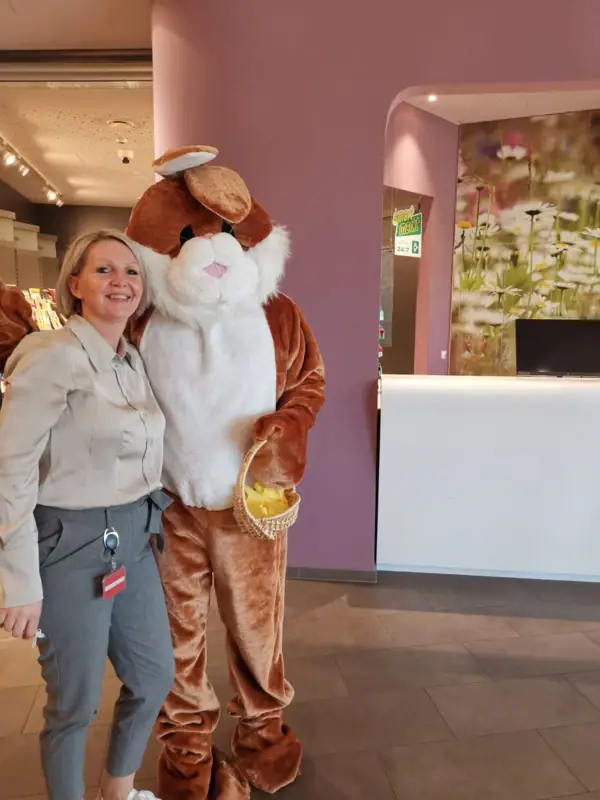 Annika und Osterhase Eine Frau steht neben einer Person in einem Kleidungsstück.