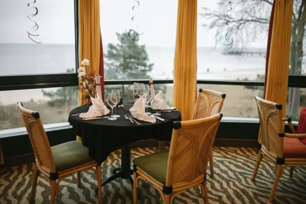 Katerfrühstück in Bansin Ein Tisch mit schwarzer Tischdecke und einer Vase mit Blumen.