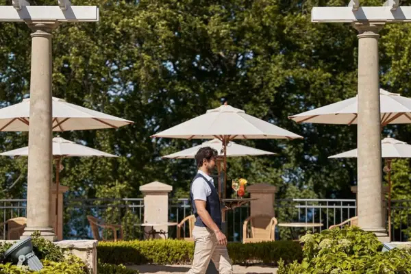Bar Außenbereich Ein Mann geht einen Weg entlang mit Regenschirmen.
