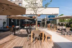 Terrasse Eine Terrasse mit Tischen und Sonnenschirmen.