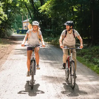 Fahrrad fahren Ein Mann und eine Frau fahren auf einem Schotterweg Fahrrad.