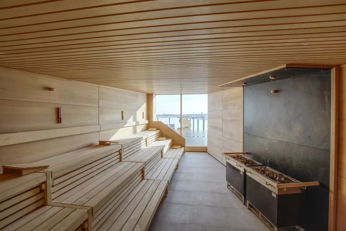 Sauna Eine Sauna mit Holzbänken und einem Kamin.