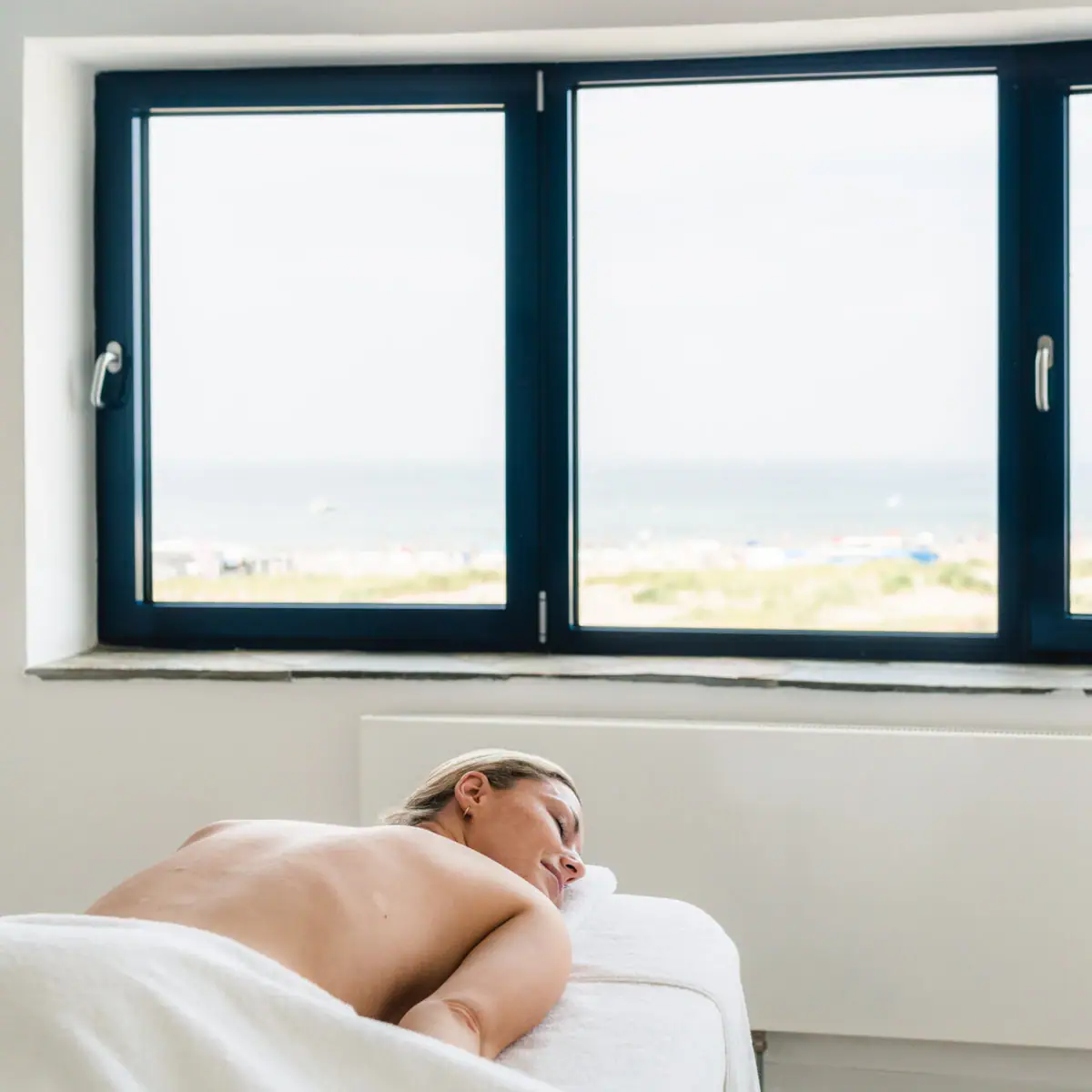 Massage Frau liegt auf einem Massagetisch