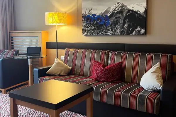 Suite Couch mit Kissen und einem Tisch in einem Zimmer.