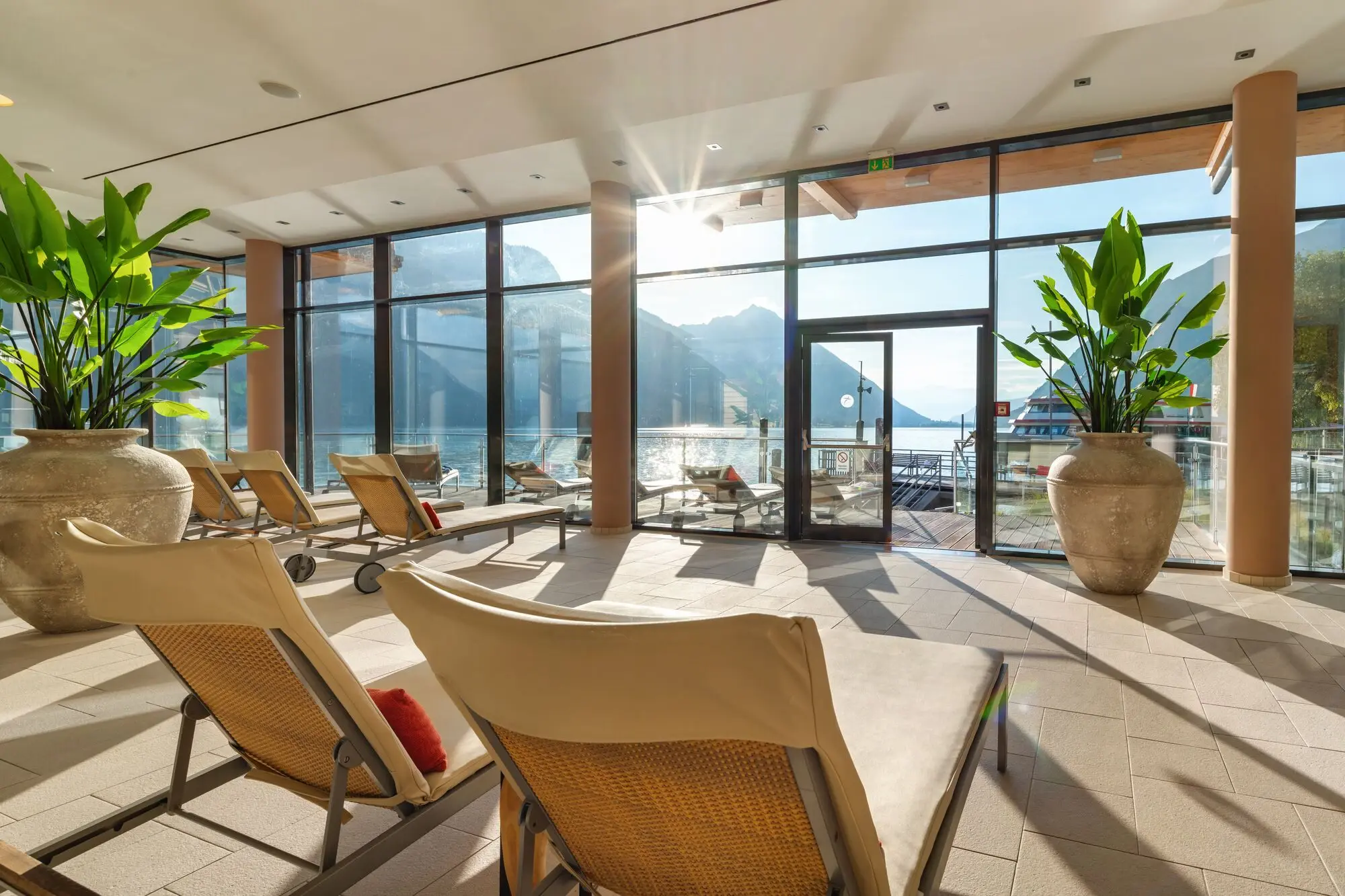 SPA im Fürstenhaus am Achensee Innenraum mit Stühlen und einer großen Glastür.