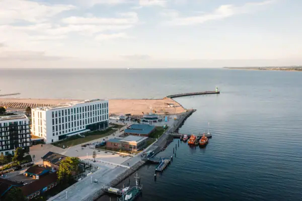 aja Travemünde Boote auf einem Gewässer mit Gebäuden im Hintergrund.