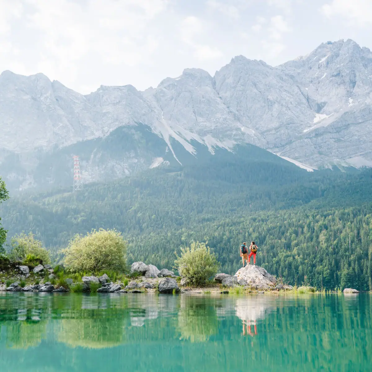 Eibsee Menschen stehen auf einem Felsen vor einem See.