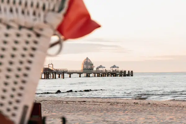 Seebrücke Ein Strandstuhl am Strand mit Blick auf das Meer.