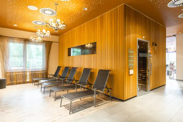 Sauna im aja Bad Saarow Ein Raum mit Stühlen und einer Tür.