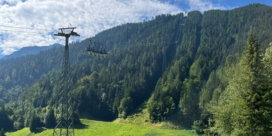 Seilbahn vor einem Bergpanorama.
