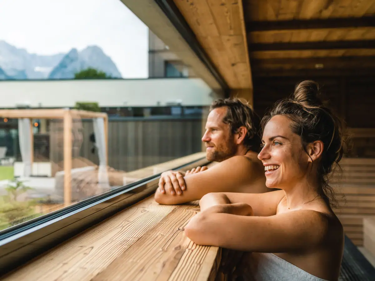 Panoramasauna Ein Mann und eine Frau blicken aus einem Fenster.