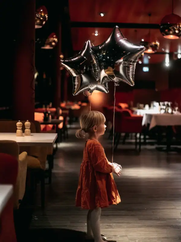 Silvesterdeko Ein Kind hält einen sternförmigen Ballon.