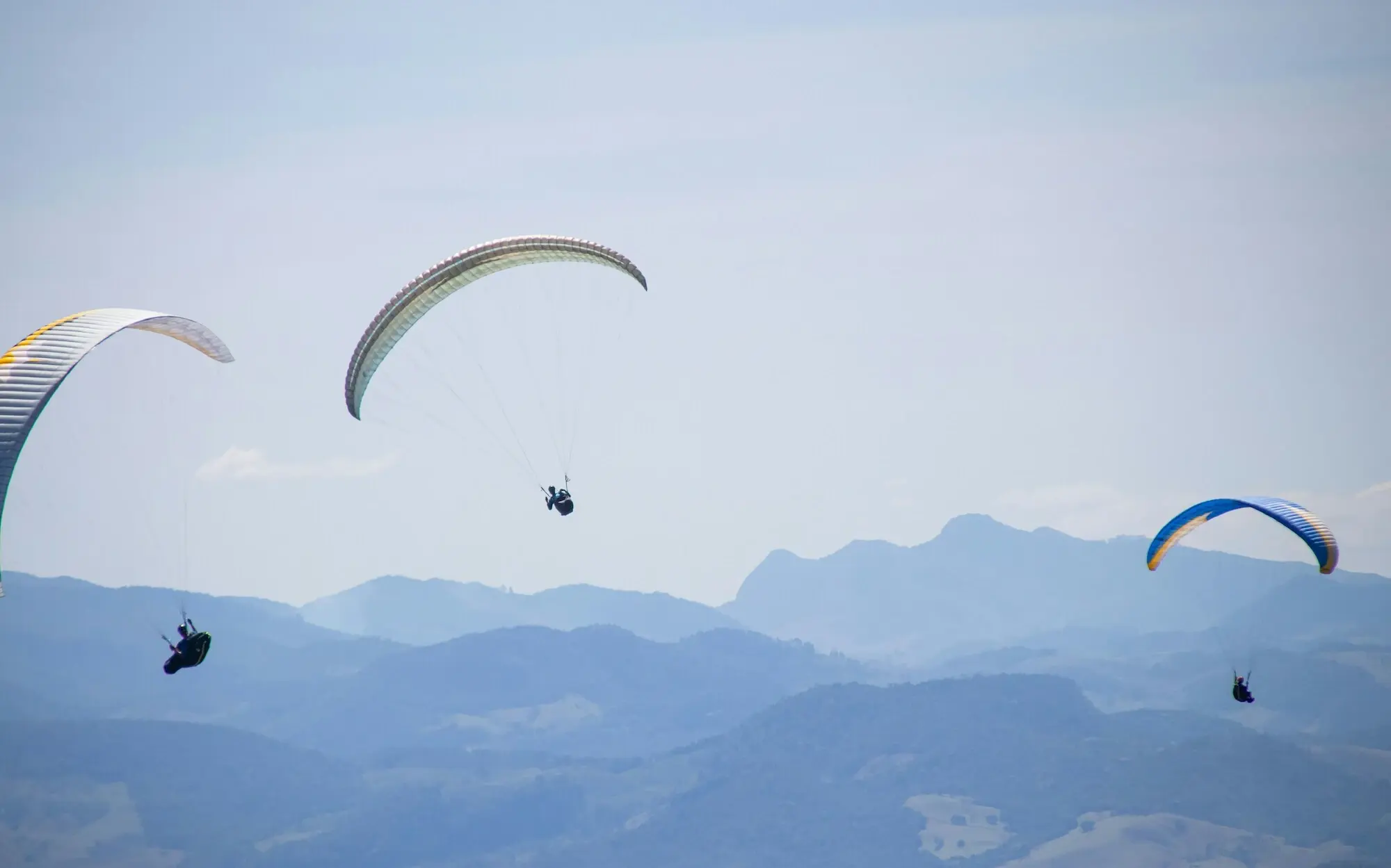 Gruppe von Personen beim Paragliding im Himmel.