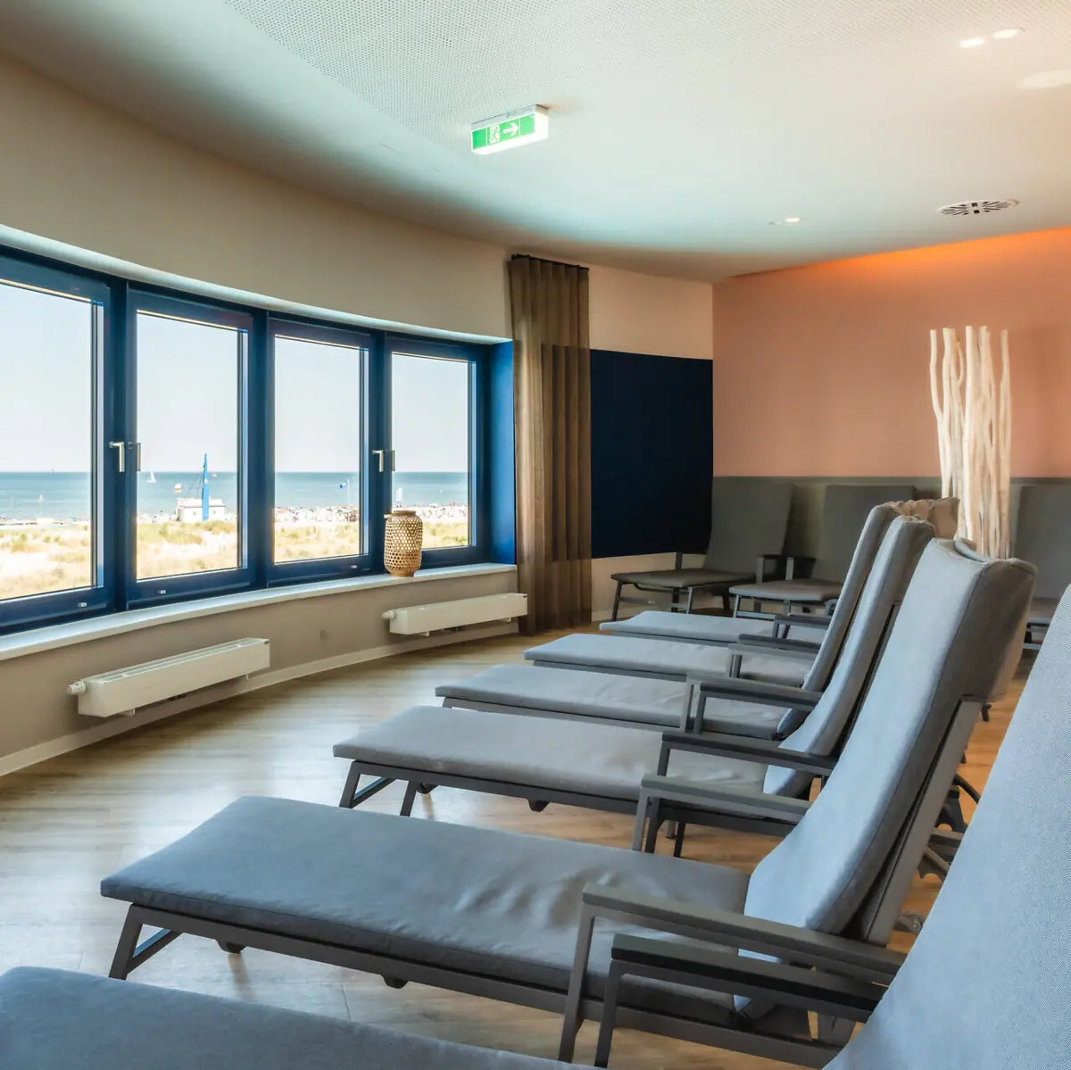 Ruhebereich im aja Warnemünde Ein Raum mit Stühlen und Fenstern, gestaltet im modernen Innendesign. Mit Ausblick Richtung Ostsee.