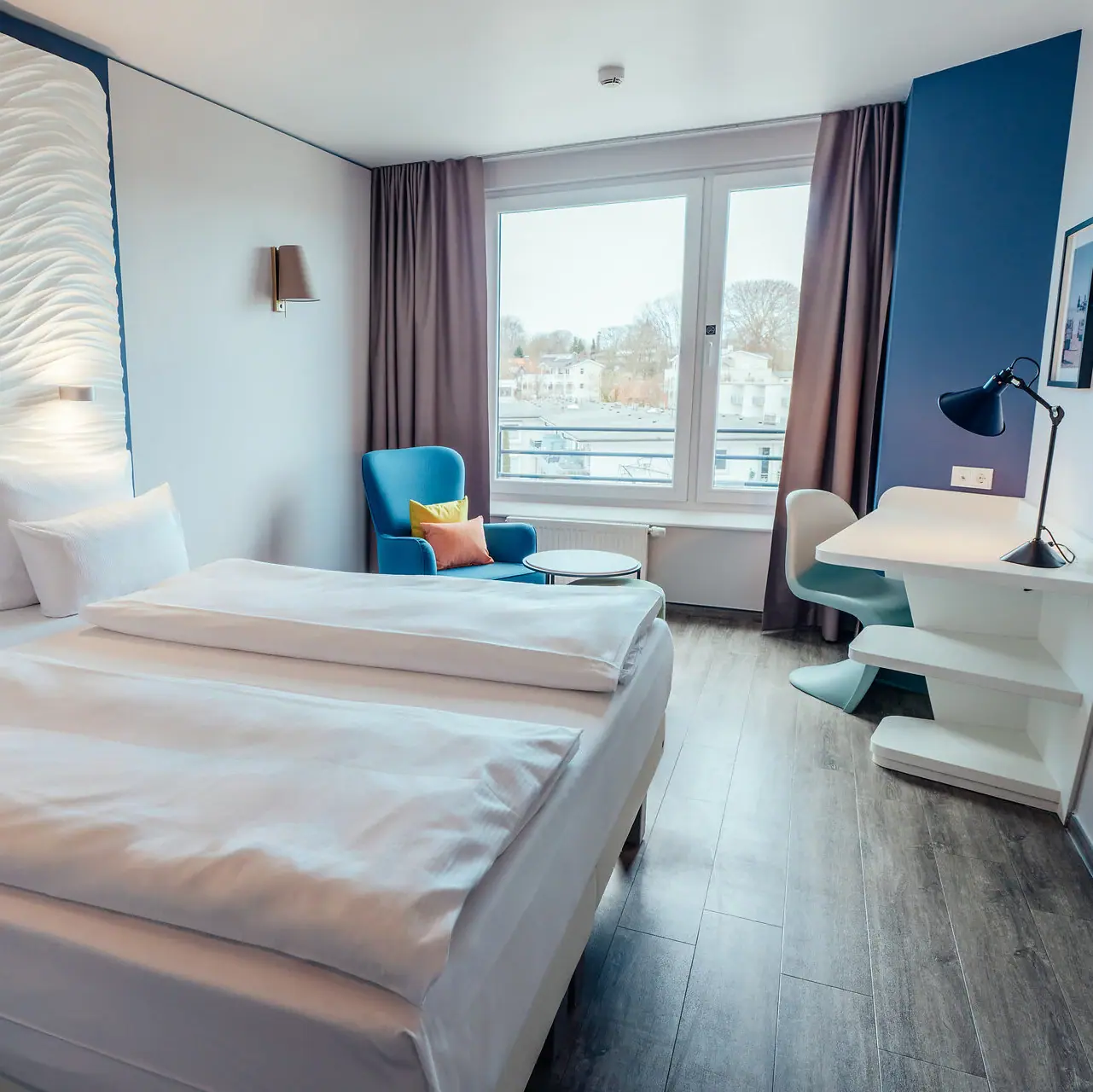 Doppelzimmer Ein Zimmer mit zwei Betten und einem Tisch.