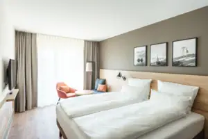 Doppelzimmer Ein Zimmer mit zwei Betten und einem Stuhl.