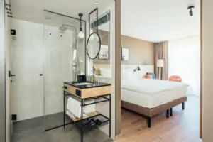 Doppelzimmer Ein Badezimmer mit einer Glasdusche und einem Bett.