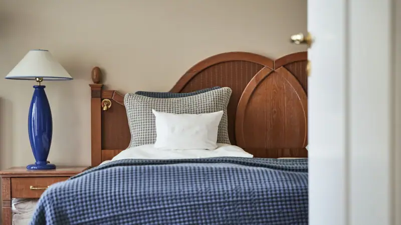 Bett mit blauer Decke und weißem Kissen