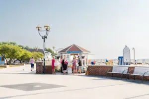 Promenade Eine Gruppe von Menschen steht vor einem Gebäude.