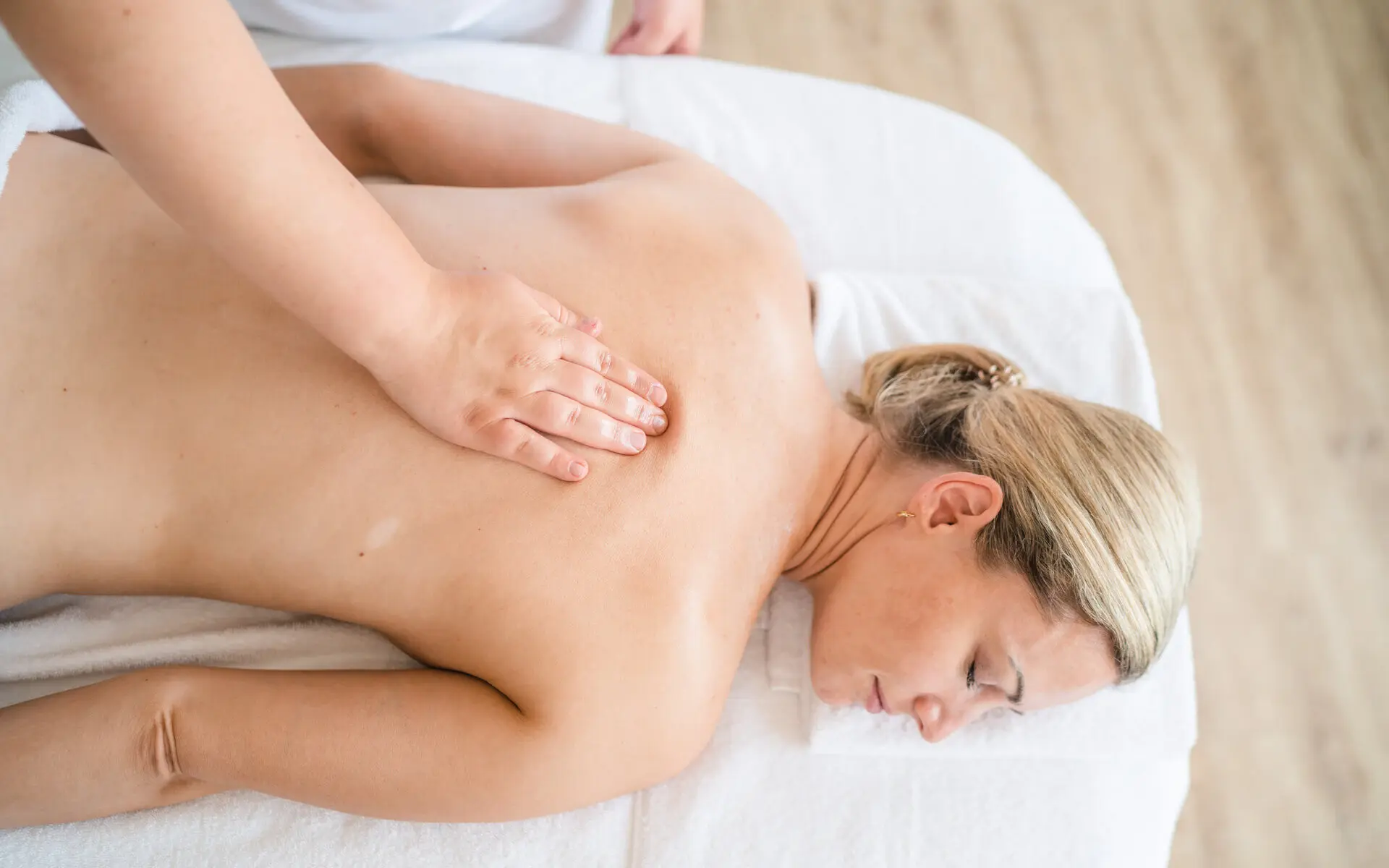 Massage Eine Frau liegt auf einer Massageliege.