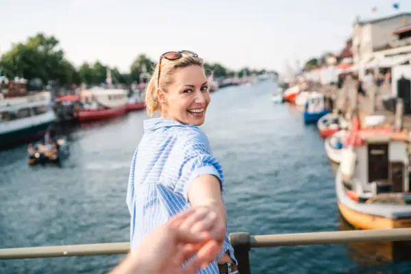 Eine Frau hält die Hand eines Mannes im Freien.