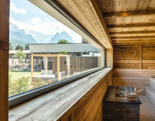 Panorama-Sauna Ein Fenster in einer Holzwand mit einer hölzernen Badewanne.