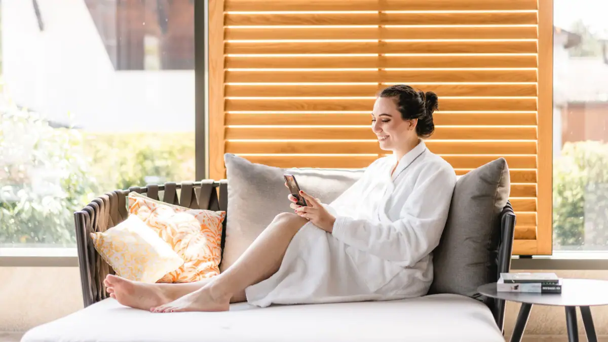 Day SPA Eine Frau im Bademantel sitzt auf einem Sofa.