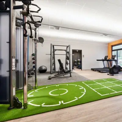 Fitnessbereich im aja Ruhpolding Ein Fitnessstudio mit Trainingsgeräten.