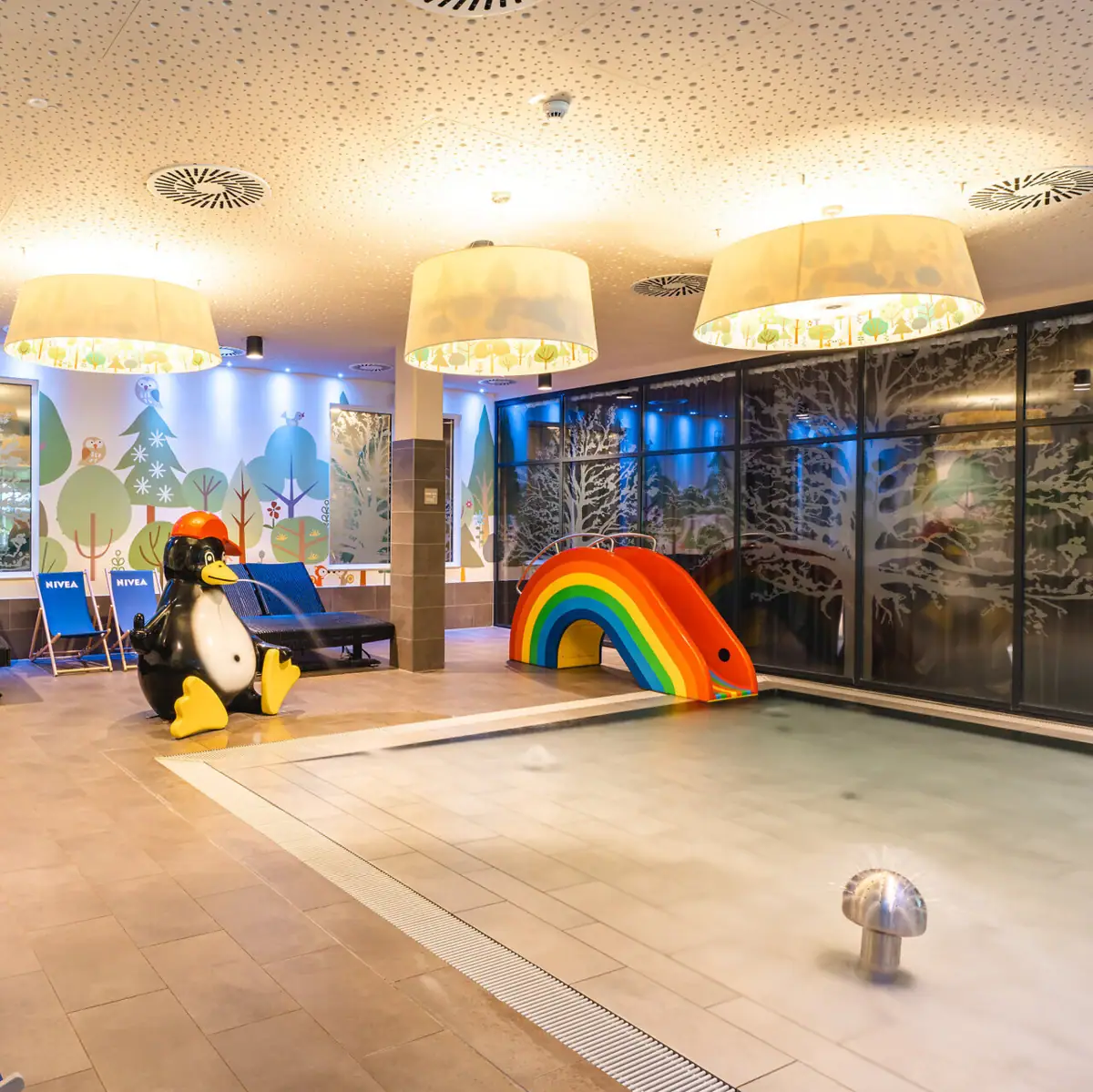 Kinderpool Ein Pool mit einem Pinguin und einem Regenbogen.