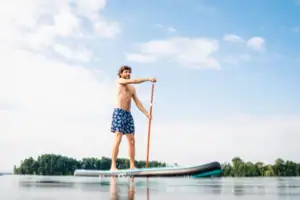 SUP Ein Mann auf einem Stand-Up-Paddle-Board auf einem See.