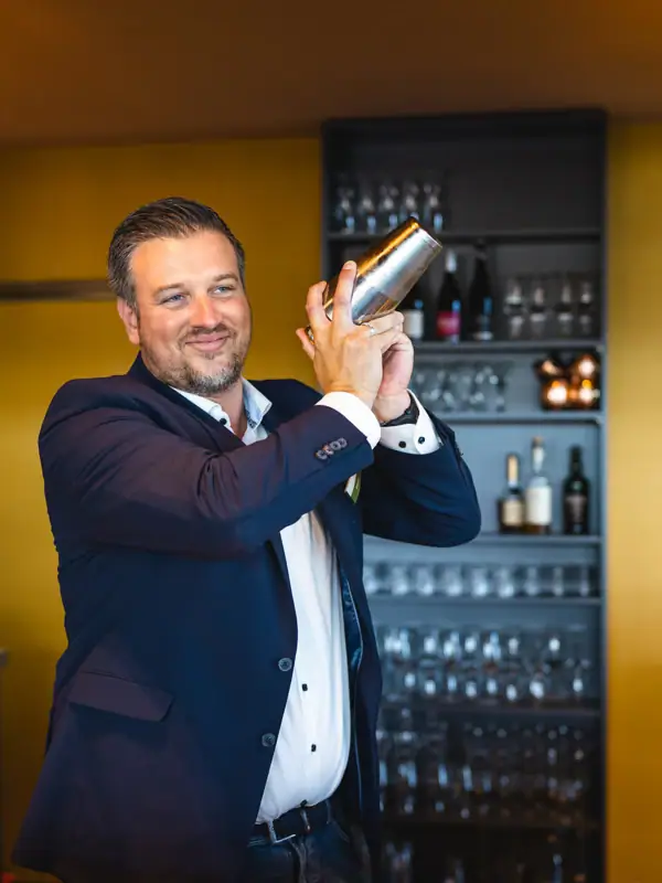 Barkeeper Ein Mann hält einen Shaker.