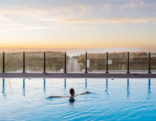 Warnemünde Außenpool Eine Frau schwimmt in einem Pool.