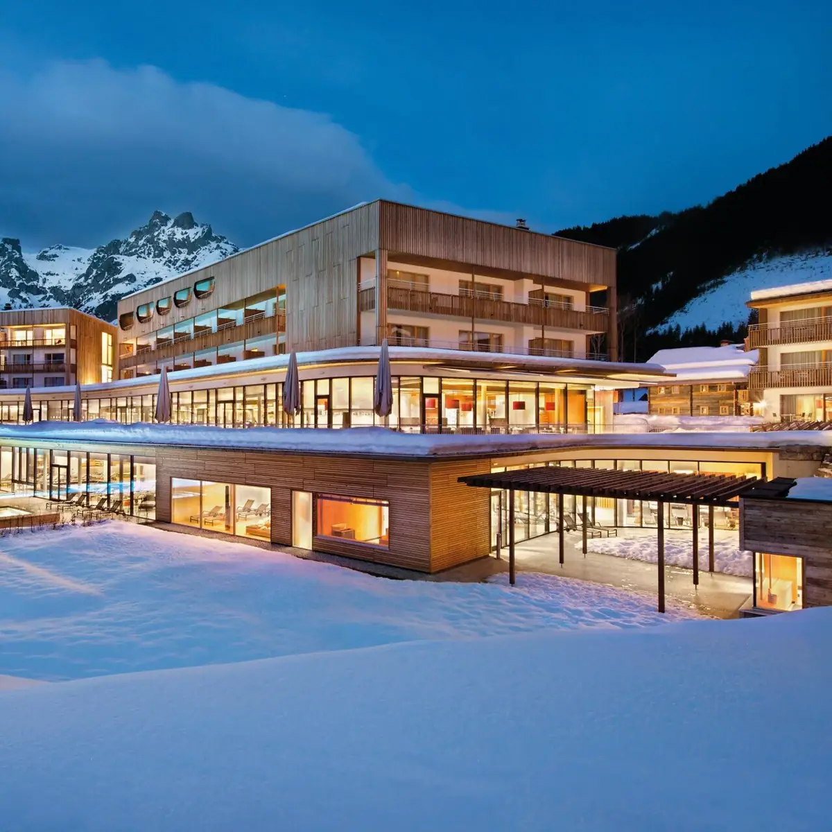 Ein beleuchtetes Gebäude auf schneebedecktem Boden.