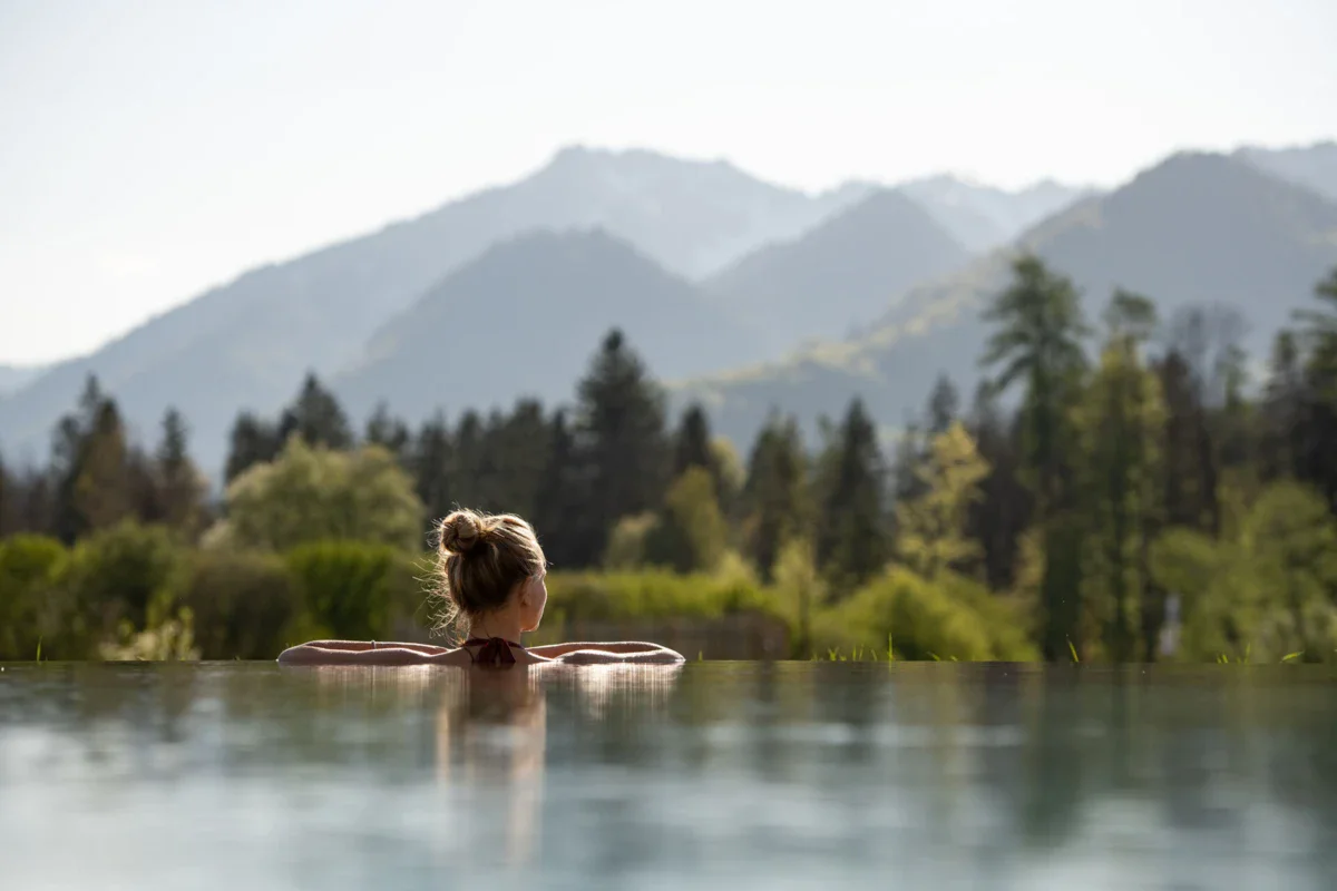 SPA Eine Frau in einem Pool im aja Hotel Ruhpolding mit Bergen im Hintergrund.