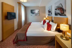 Zimmer Achensee Ein Bett mit Kissen und einem Fernseher in einem Hotelzimmer am Achensee.