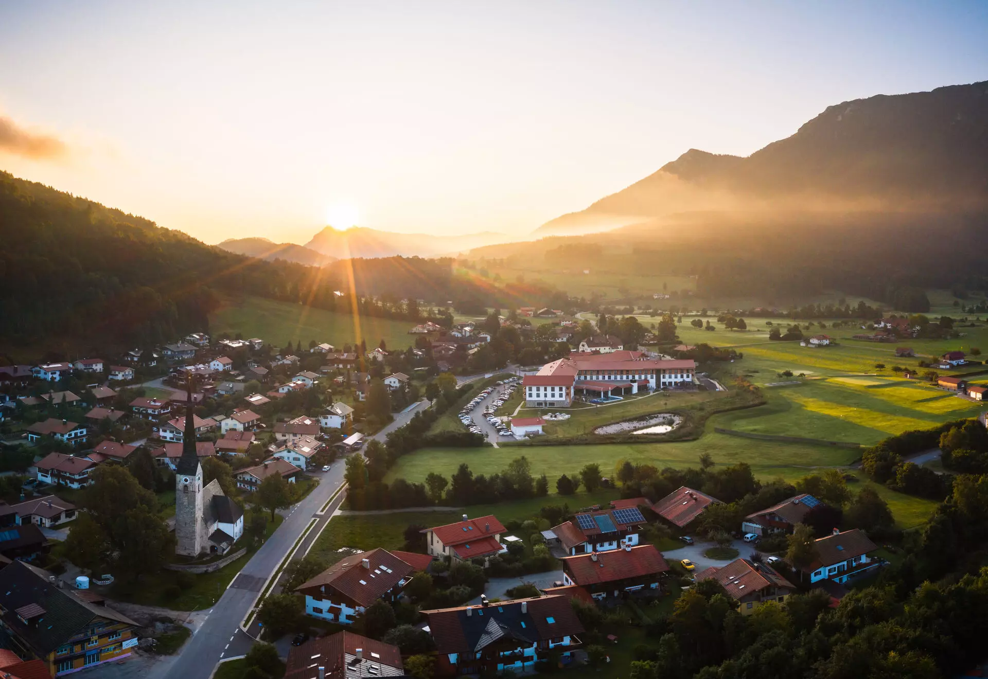 aja Ruhpolding Großes Gebäude mit einem Pool und Gras