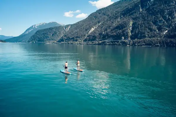 Aktivitäten am Achensee im Sommer Zwei Personen auf Paddleboards auf einem See.