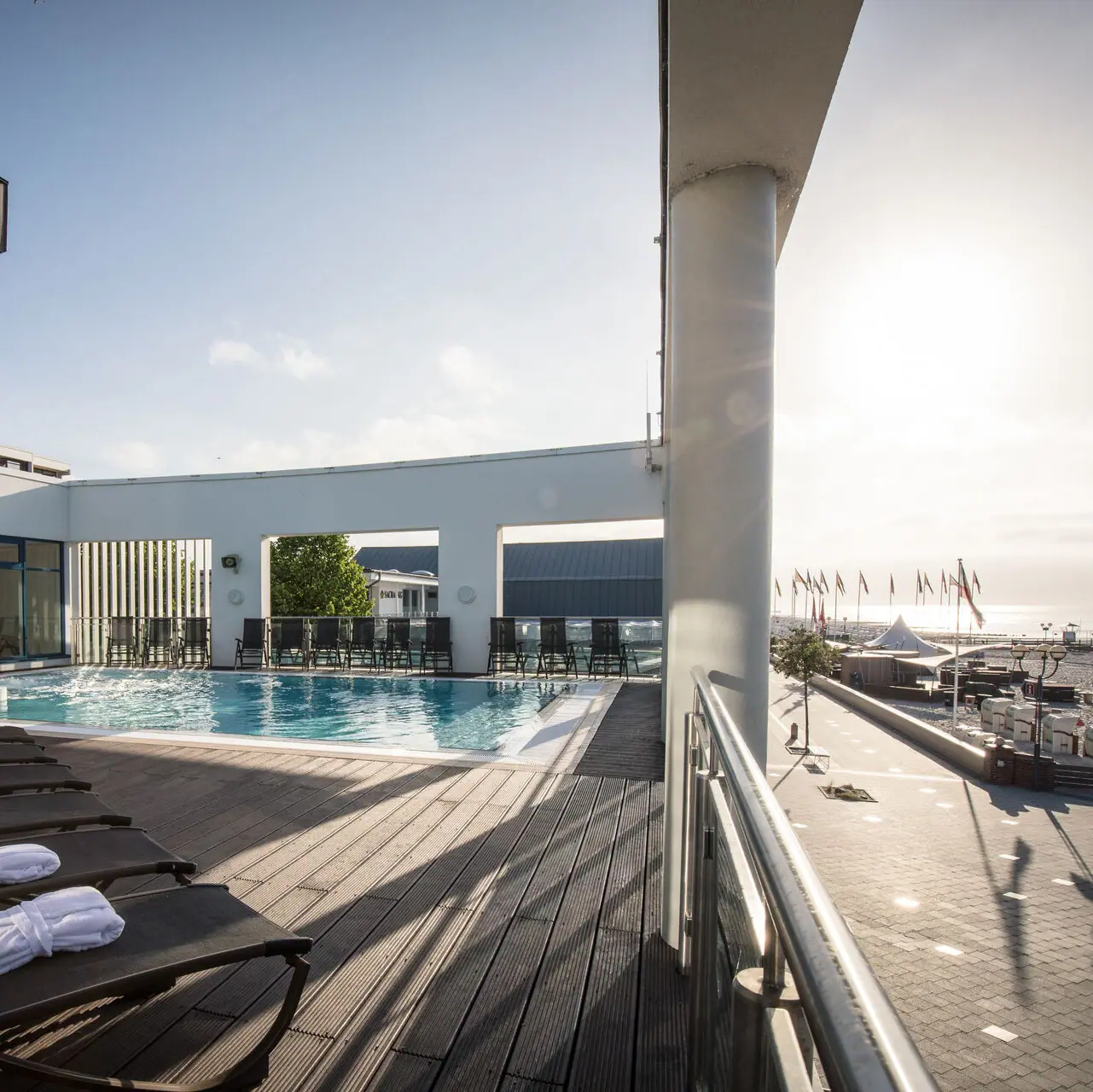 Außenpool Grömitz Schwimmbecken mit Liegestühlen und Holzterrasse im Freien.