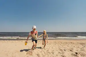 Strandtag Ein Junge und ein Mädchen rennen am Strand.