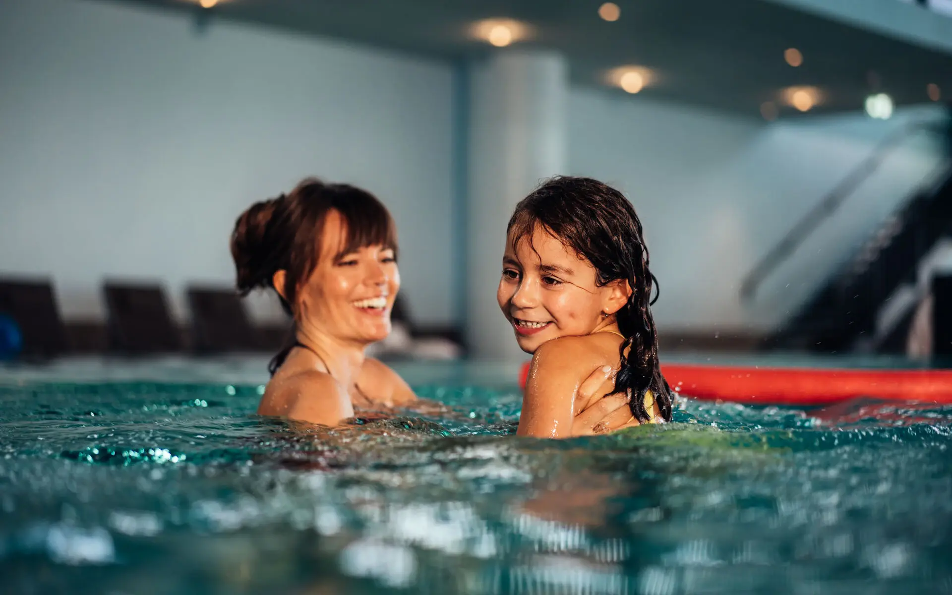 Kinderschwimmen Eine Frau und ein Mädchen im Schwimmbad