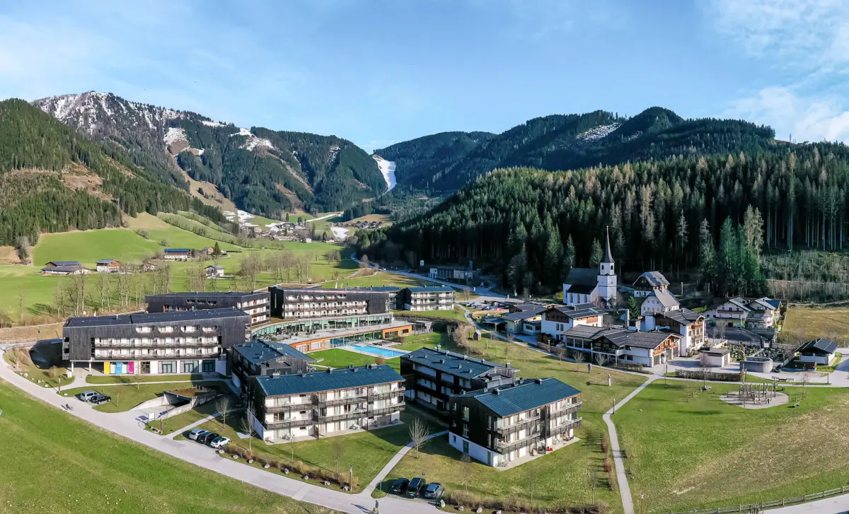 aja Bergresort Werfenweng Das aja Bergresort Werfenweng von oben aus der Luft fotografiert mit Bergen im Hintergrund.