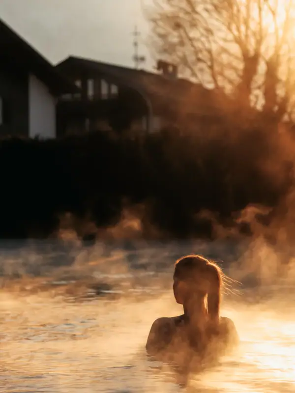 Außenpool im Winter Eine Frau in einem dampfenden Pool im Freien.