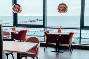 Restaurant Ein Raum mit Blick auf den Ozean und einen Pier.