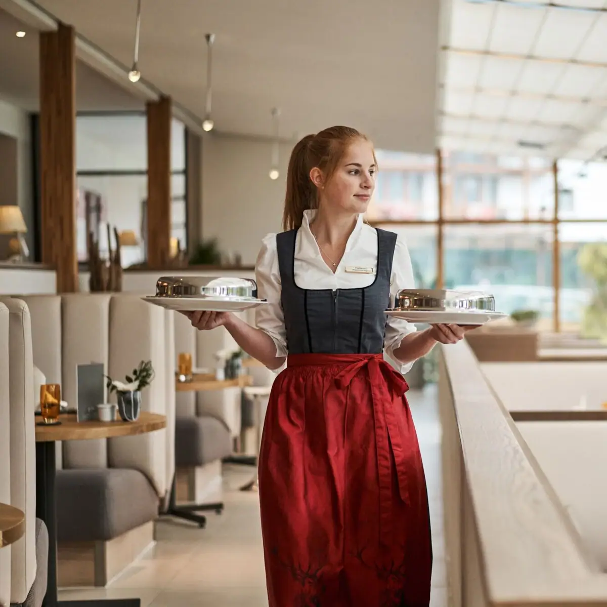 Servicemitarbeiterin Eine Frau hält zwei Teller.