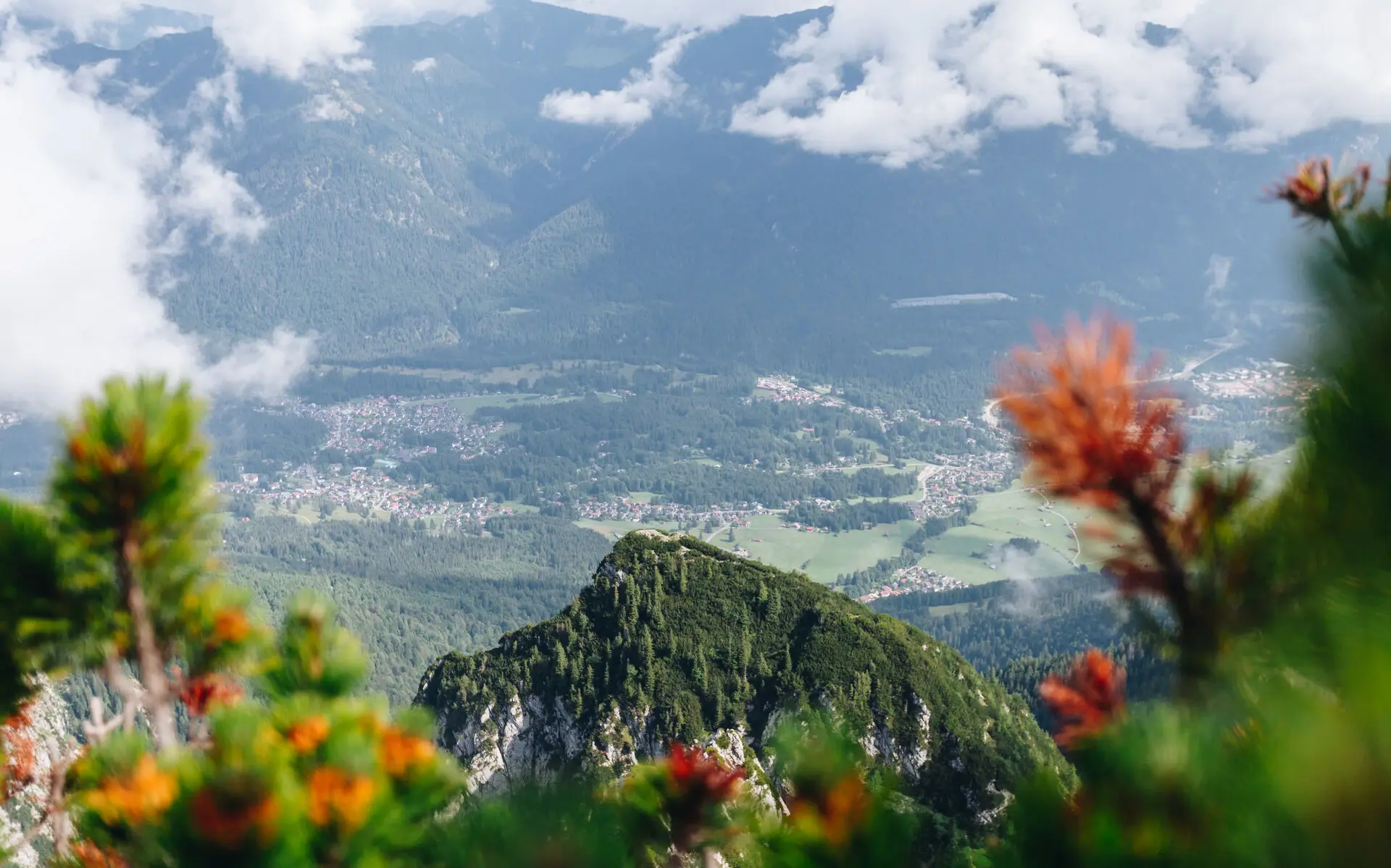 Ein Blick durch die Wolken hindurch auf Dörfer im Tal.